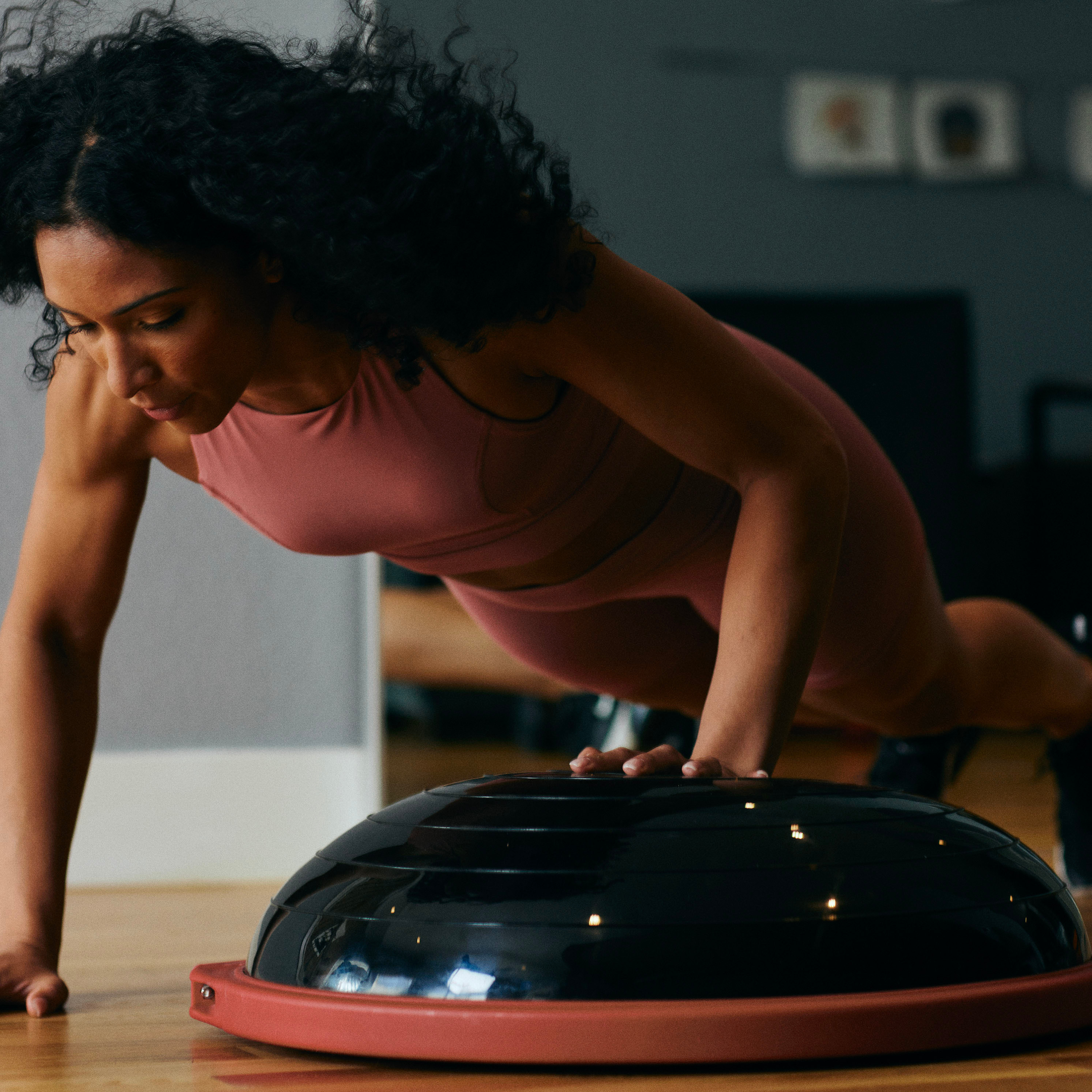 Woman doing single arm push-up on Balance Trainer Pro